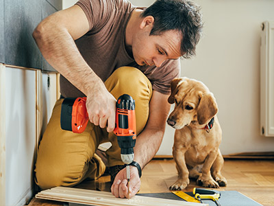 A man doing work with a puppy next to him